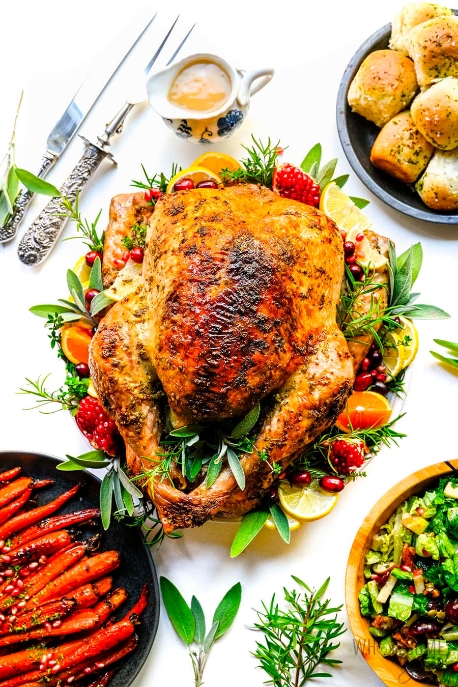 Heritage turkey served with roasted vegetables and herbs on a white plate.