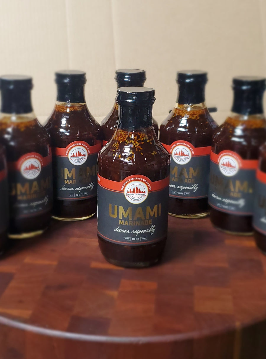 Bottle of Umami Marinade showcasing a rich brown color, surrounded by similar bottles.