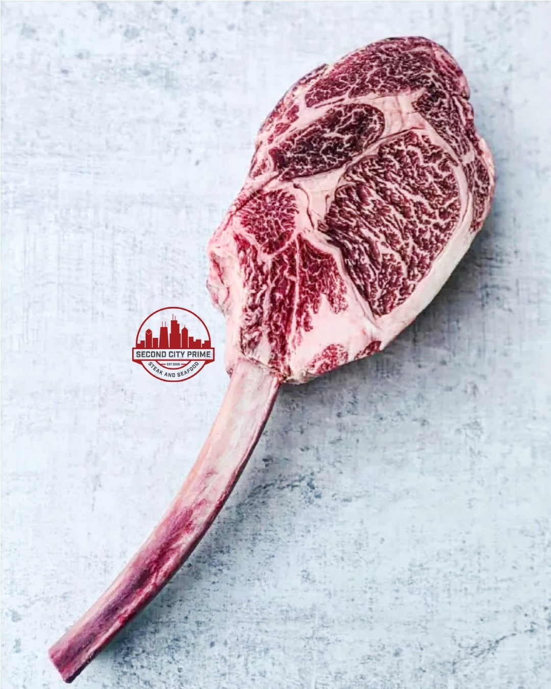 32oz Australian Wagyu Tomahawk Ribeye with rich marbling and long bone, perfect for sharing.