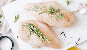 Raw Second City Prime chicken with herbs and spices.