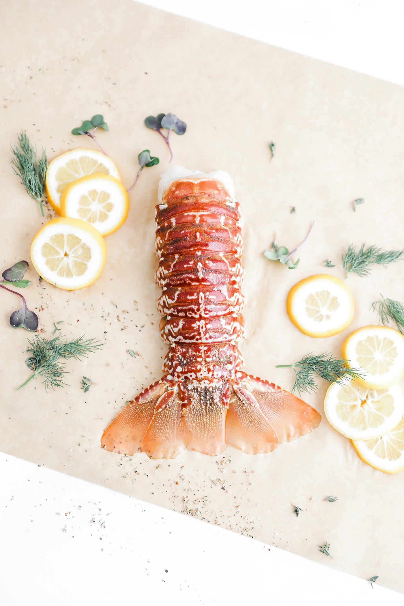 Second City Prime lobster tail with herbs and lemon slices.